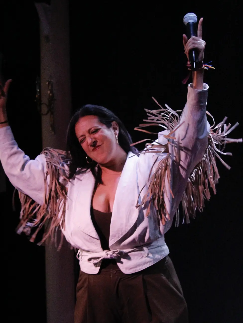 María A Secas celebrando sobre el escenario con el micrófono en alto